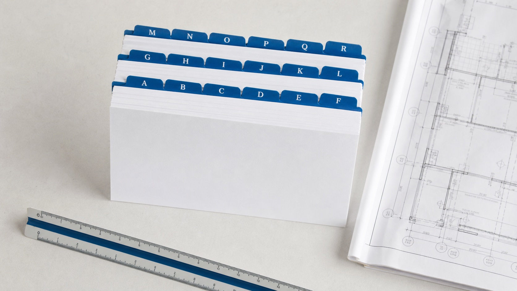 Alphabetised construction reference cards beside a drawing and scale ruler
